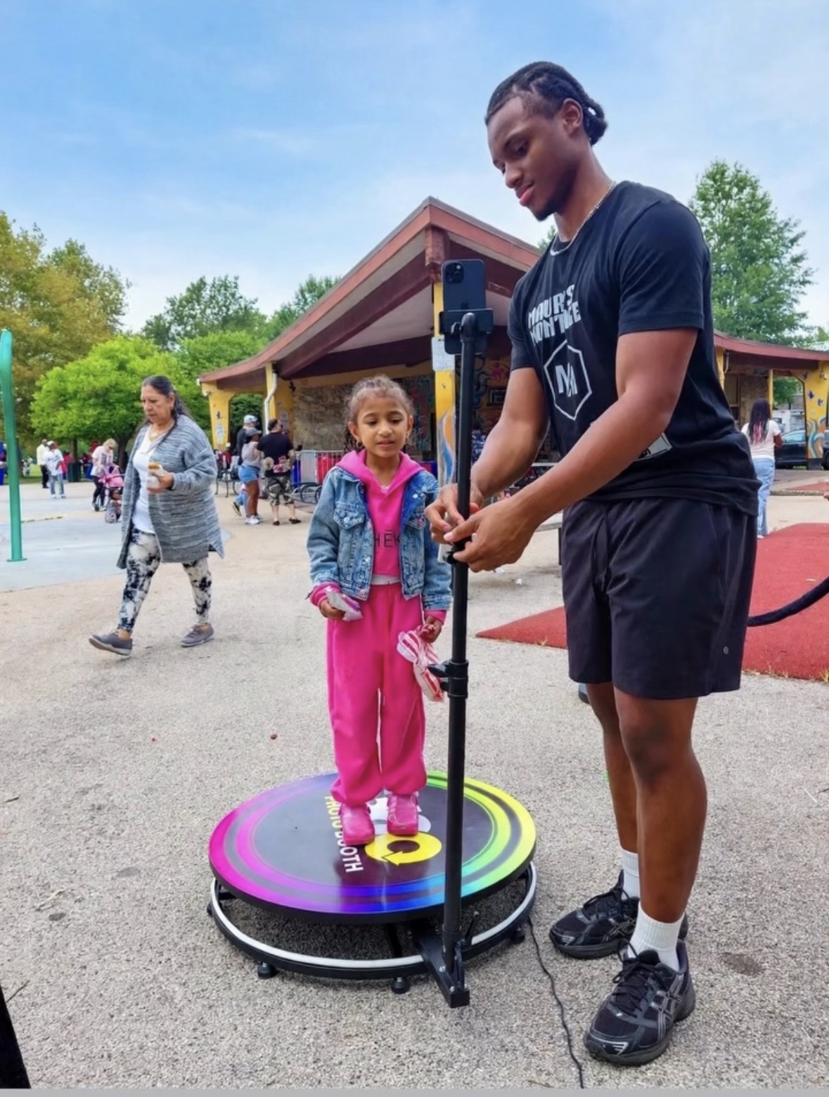 Attendant setting up the 360 photo booth for a young guest